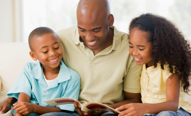 A father reading with his two young children