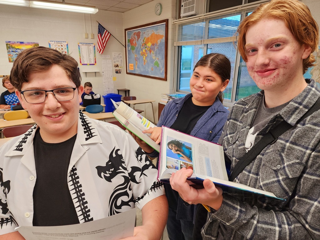 three students holding books